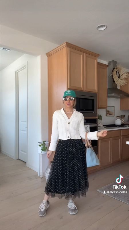 When I don’t know what to wear and what to be comfy outfit 🫶🏻 my Abercrombie cardigan on repeat here with a black midi skirt I’ve had forever! Sharing midid skirts I love as well as my favorite green graphic dad cap, shopping tote, and Reebok sneakers on major sale today ✨🛍️ 

#LTKVideo #LTKstyletip #LTKshoecrush