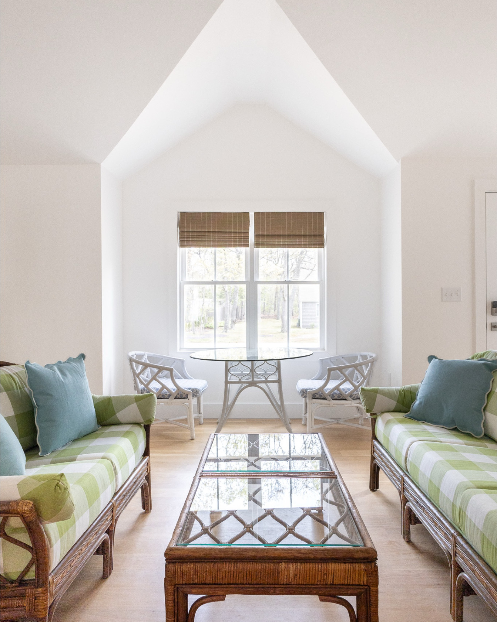 the original living room at the #preppyhollowhouse had a lot of great features to work with: vaulted ceilings, double windows, and a fireplace. to maximize the space and let more light in, we removed a wall that divided the living room and kitchen. we also removed the dated fan-shaped window and gave the fireplace a facelift with a new surround and lots of fresh white paint. a vintage rattan couch and loveseat balance out the white, while green gingham upholstery adds a pop of color. #dwelloctoberstay #dwelloctober

#LTKHome
