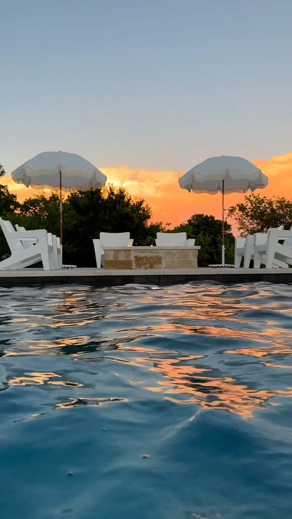 Summer nights by the pool featuring Tupelo Chairs & Amazon umbrellas!