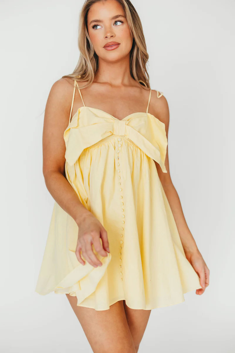 Irelyn Babydoll Mini Dress with Bow Accent in Yellow | Worth Collective
