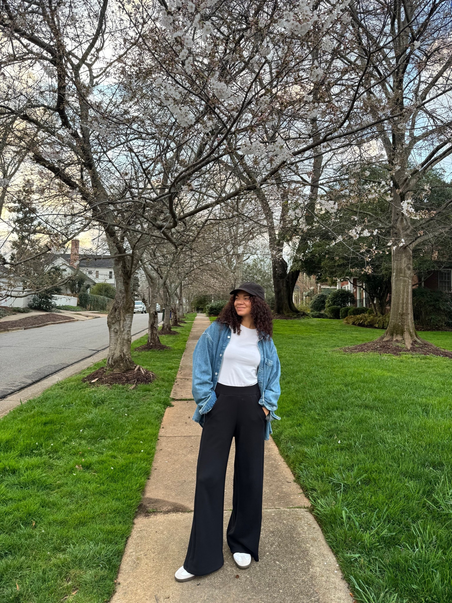 Casual spring outfit with a denim oversized utility shirt jacket, black pants, baseball cap, white tee, and sneakers 

#LTKootd