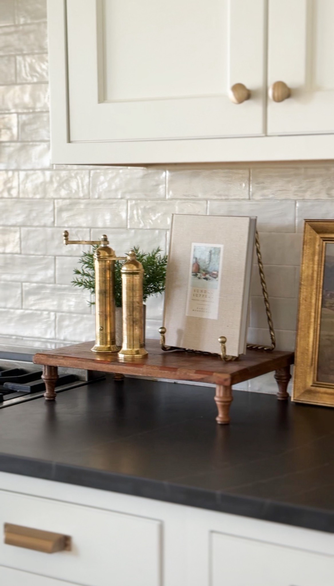 Kitchen counter styling moment 🤍
I added a wooden riser with brass salt and pepper mills, a favorite cookbook, and a faux rosemary plant for a natural touch.

It keeps everyday items within reach while still feeling styled and pulled together.

I’ve linked everything below if you want to recreate the look.

#LTKHome