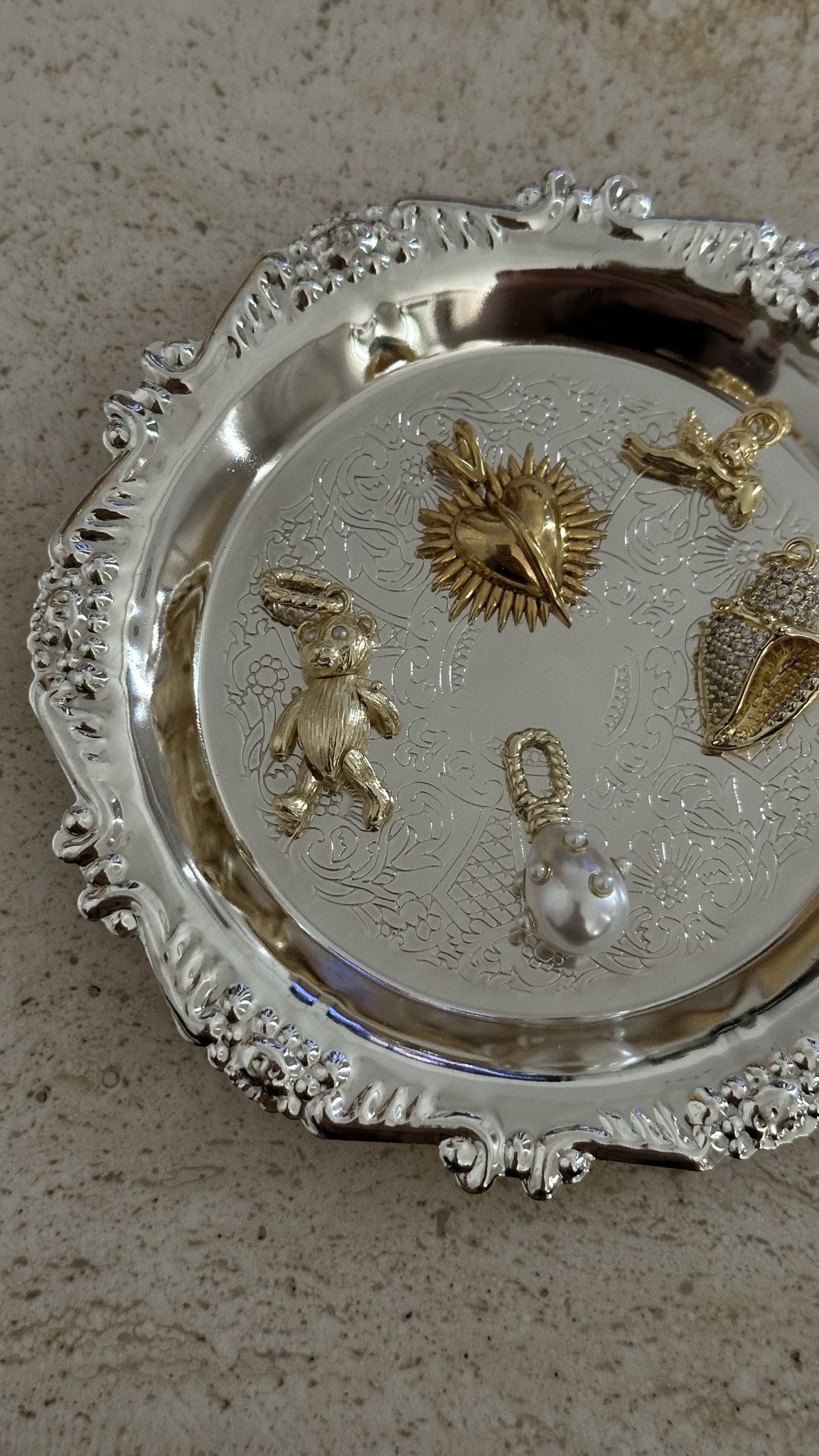 A Friday tray of tiny treasures - a bear, studded pearl, sacred heart, cherub and a diamond shell. Proof that little charms can do the heavy lifting. ✨
.
jewellery edit | silver tray flatlay | bear charm | studded pearl charm | sacred heart charm | cherub charm | diamond shell charm | jewellery styling | everyday charms | statement jewellery | elevated details | charm collection 

#LTKluxury #LTKgiftguide #LTKautumn