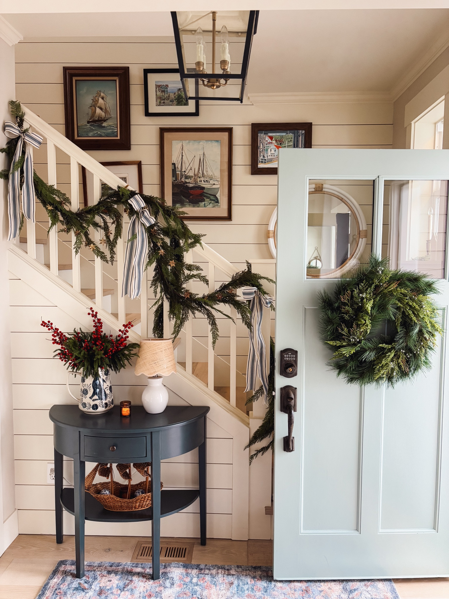 Entry decor Christmas - table, lamp, garland, striped ribbon, wreath, rug, pitcher, berries, greenery, rattan mirror, lantern and more 

#LTKHoliday #LTKHome #LTKSeasonal
