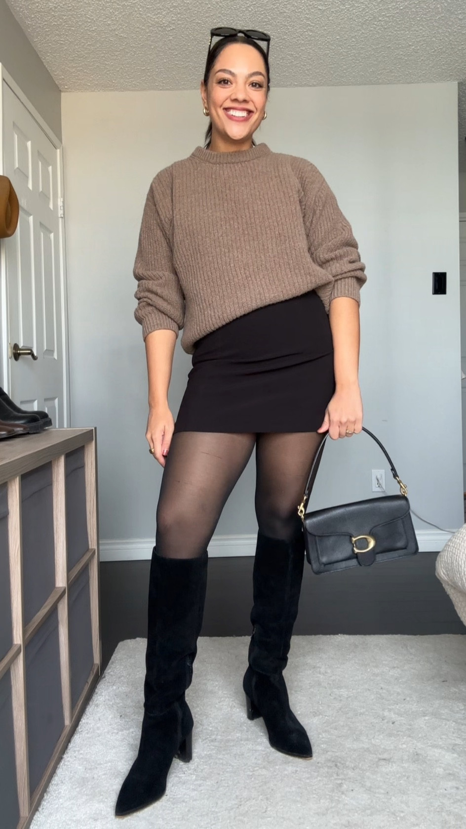 Ways to wear a crewneck sweater! Details below:

-Poppy Barley crewneck sweater in the colour dune. Made with 100% superfine lambswool. Super soft and versatile! I’m wearing a large. 
-Dynamite black mini skirt, I have a medium. 
-H&M tights, I have a large. 
-Black suede knee high boots, similar linked. 
-Coach tabby shoulder bag 26 in black pebble leather  
-COS gold mini hoops. 
-Celine Triomphe 52mm sunglasses in black acetate. 

#LTKfindsunder100 #LTKSeasonal #LTKstyletip