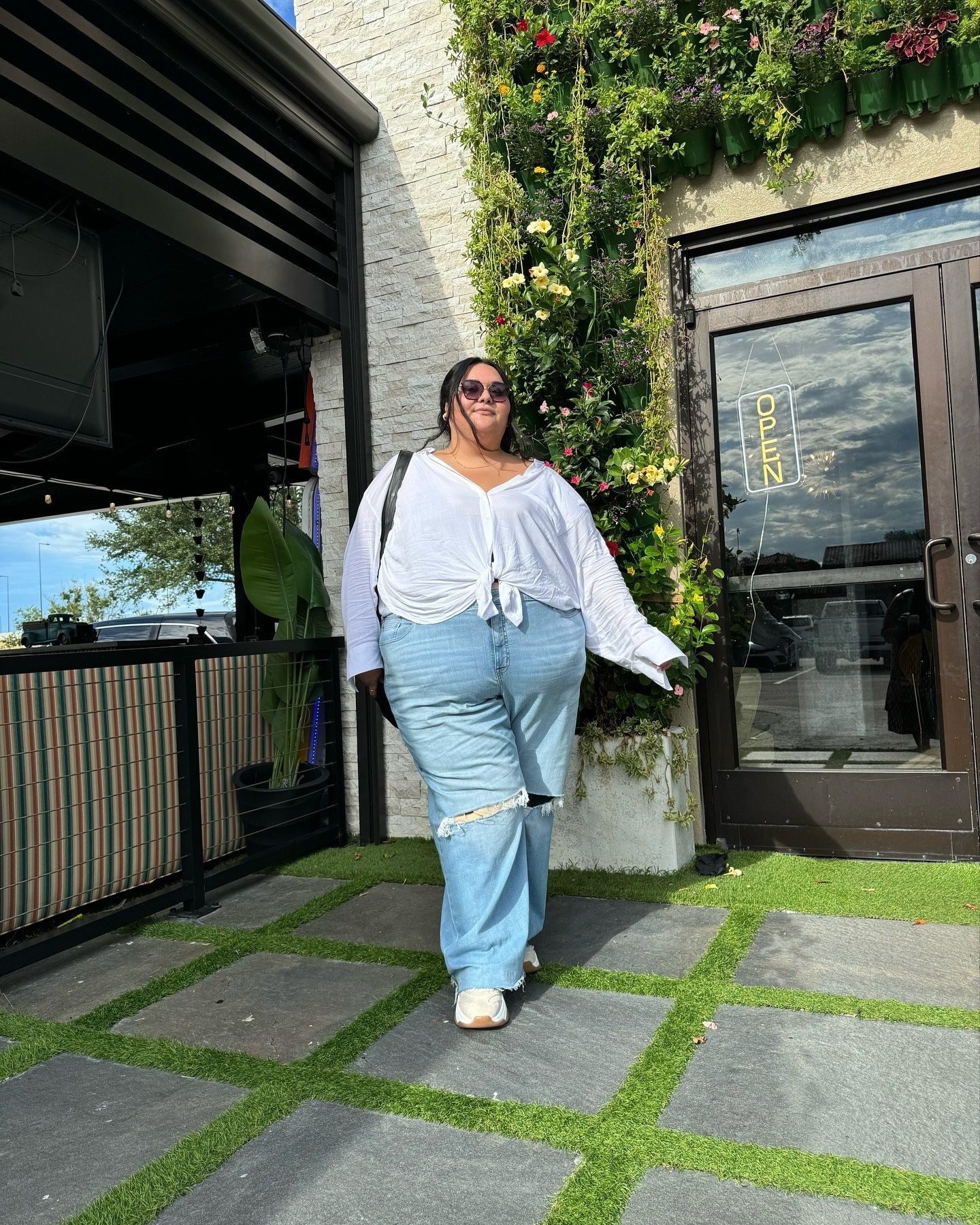 Plus size summer outfit. Sizes 10-30. Just a sweaty girl trying to appear cool. 

Loose rayon white button down shirt, wide leg light wash distressed jeans, tan and white sneakers wide width shoes, black leather bag, sunglasses 

#LTKFindsUnder50 #LTKPlusSize #LTKSaleAlert