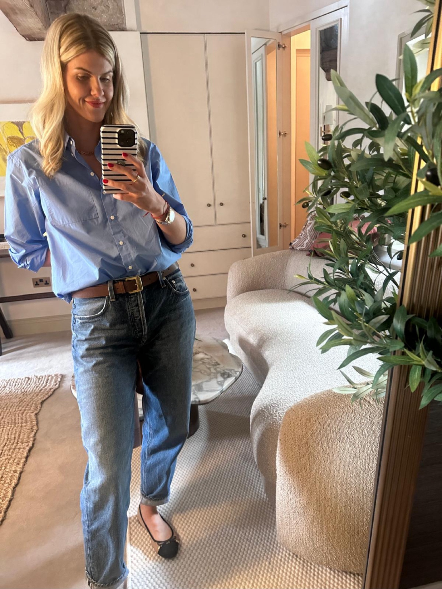 Blue button up shirt with washed out blue jeans with a miu miu belt and flats

#LTKworkwear #LTKstyletip