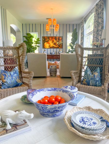 View from lattice room to the living room. Serena and Lily chandelier steals the show  Blue and white curtains, swivel rockers, striped wallpaper, pillows, coastal style 

#LTKhome #LTKsalealert
