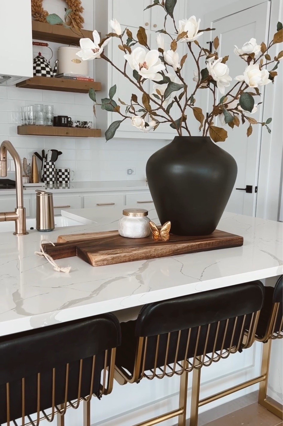 kitchen decor with faux magnolia stems that I absolutely love! Looks life like and quality is great. Our transitional kitchen has leather and brass counter stools, brass hardware, brass kitchen faucet and floating shelves.

#LTKSeasonal #LTKHome