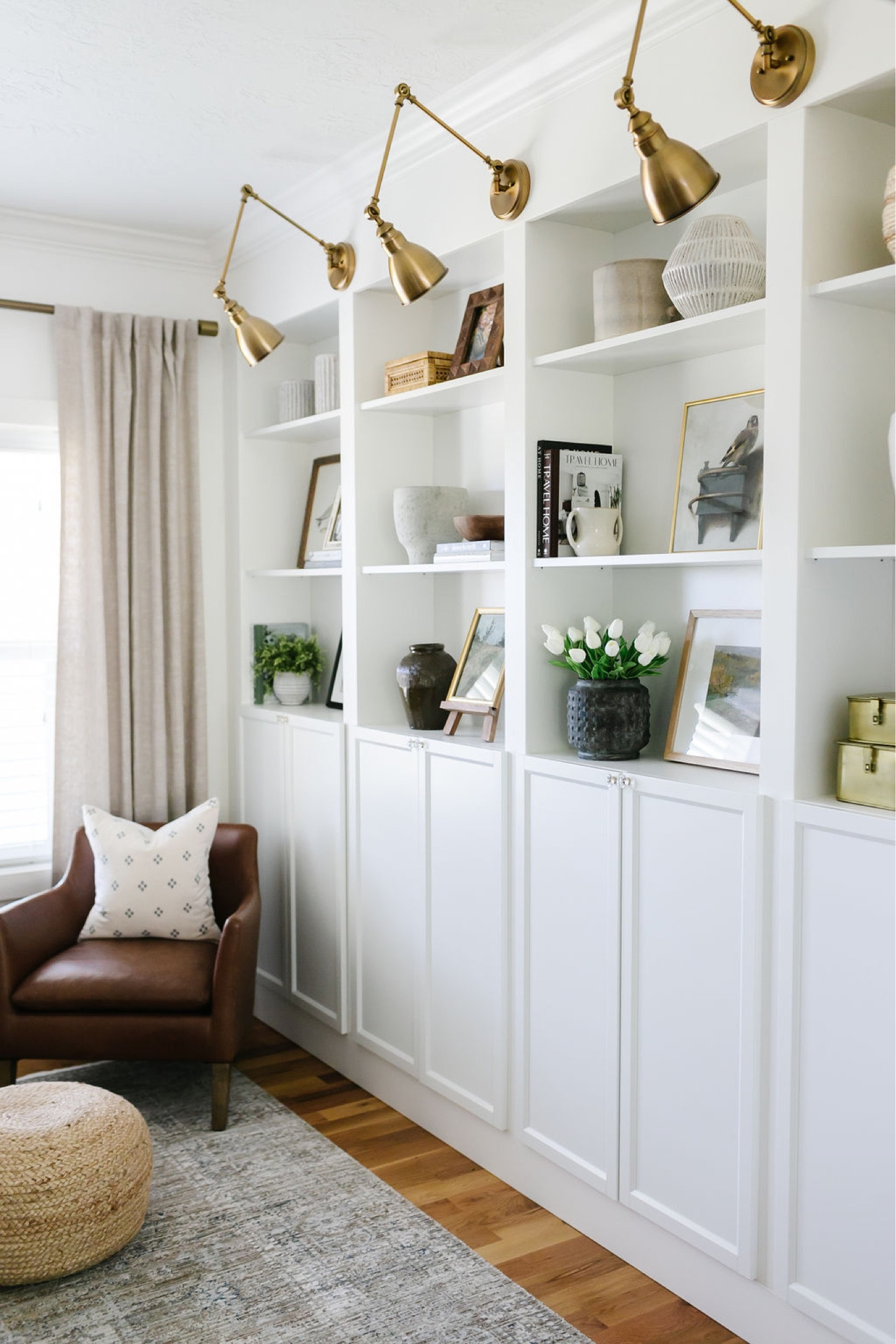 My den / home office has a leather chair, oatmeal colored drapery, neutral area rug, brass sconces. The shelves are an IKEA hack. Details on my website  

#LTKFind #LTKhome #LTKsalealert