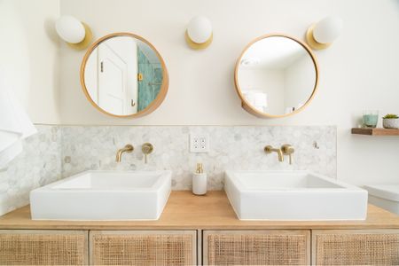 This is our kids’ bathroom where we went with a fun, beachy vibe.  Love these medicine cabinets mirrors from Amazon!  We also converted a rattan console into a vanity for a custom look.  #bathroomdesign #bathroomdecor #bathroom 

#LTKhome #LTKunder100 #LTKunder50