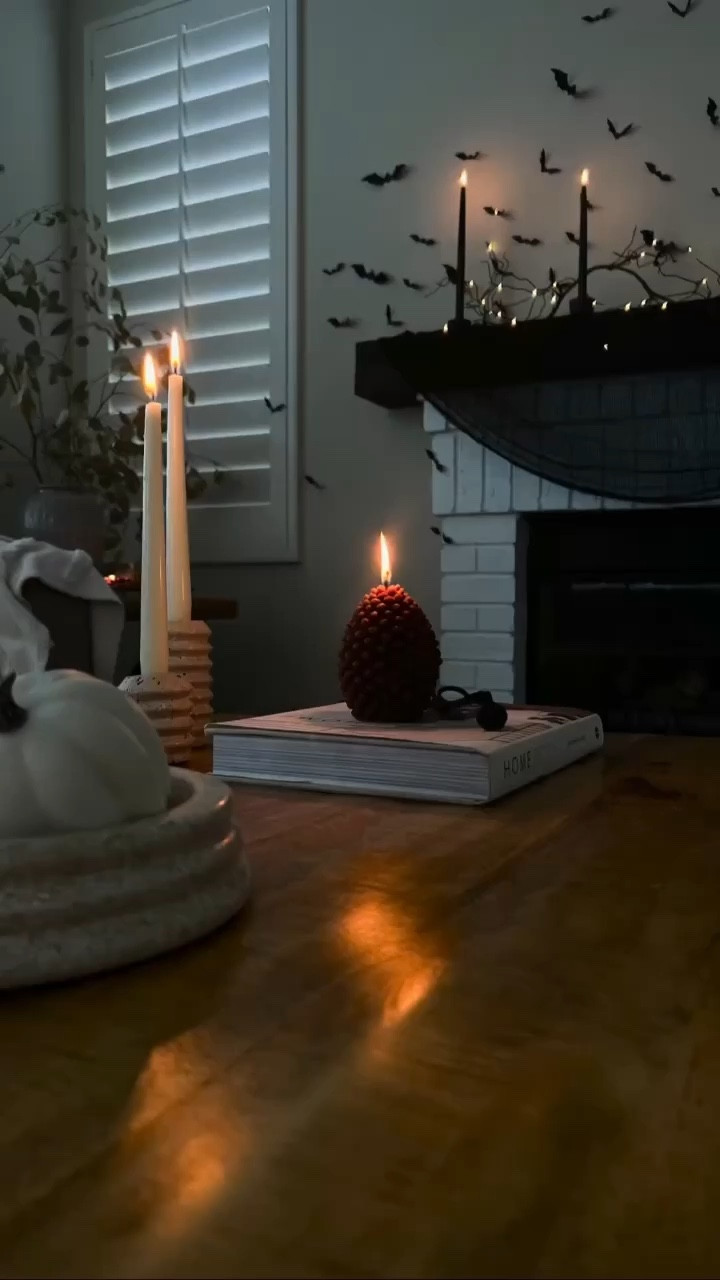 Spooky Halloween vibes in our living room! 
Black Candles , taper candleholder, travertine candleholder, ivory taper candles, pinecone candle, black gauze creepy cloth, Halloween decor, plastic 3D bats, branch led lit garland
#LTKhome 

#LTKHalloween #LTKVideo