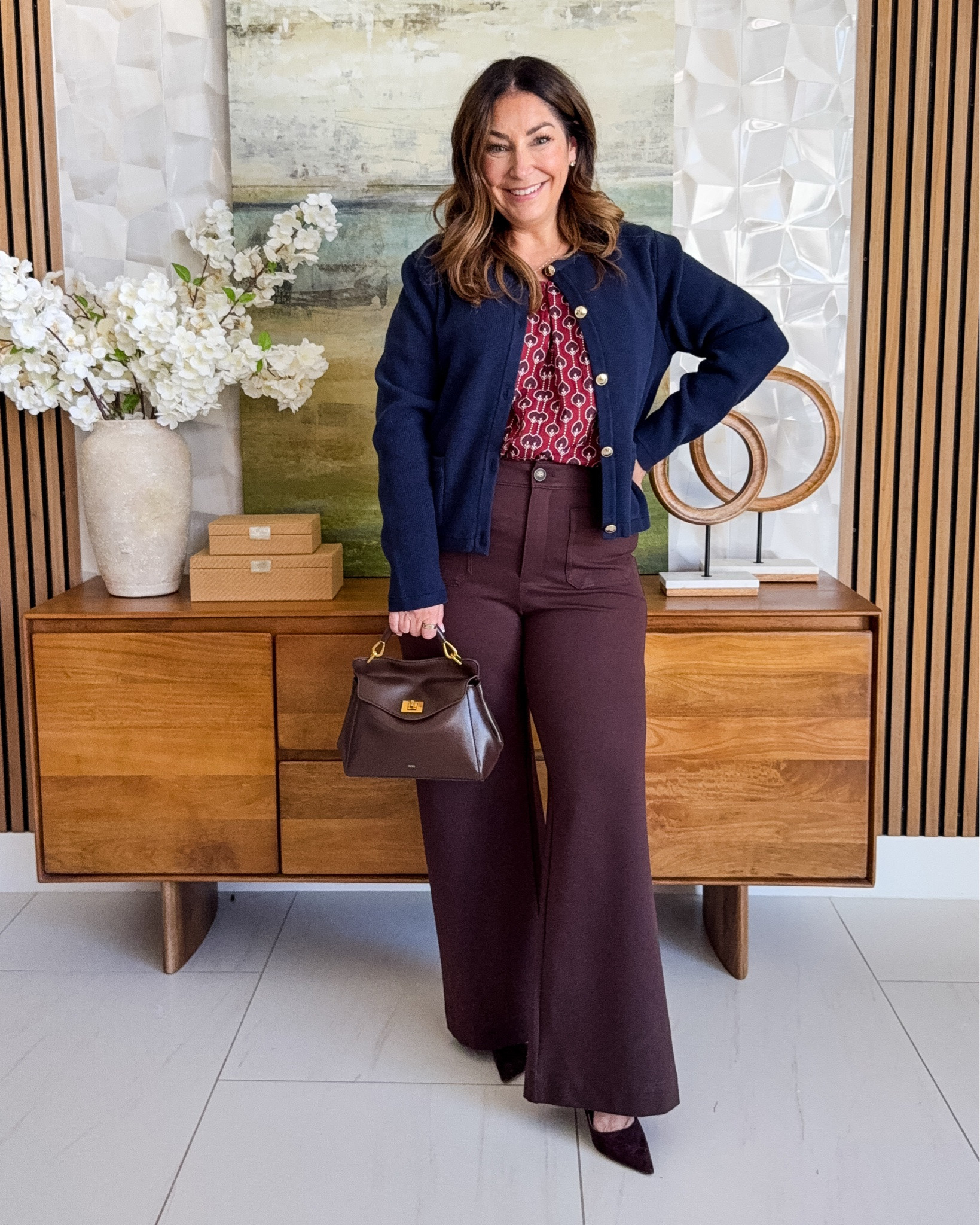 Fall workwear layers 💙 Navy crewneck cardigan with gold buttons over a burgundy geometric print blouse, paired with wine wide-leg trousers, a brown top-handle bag, and burgundy suede pumps. A navy + wine teacher outfit and business casual look for cooler days.

Sizing: sweater tts, L // Blouse tts, L // pants size up if in-between, 12 

@loft   @quince

#LTKOver40 #LTKMidsize #LTKWorkwear