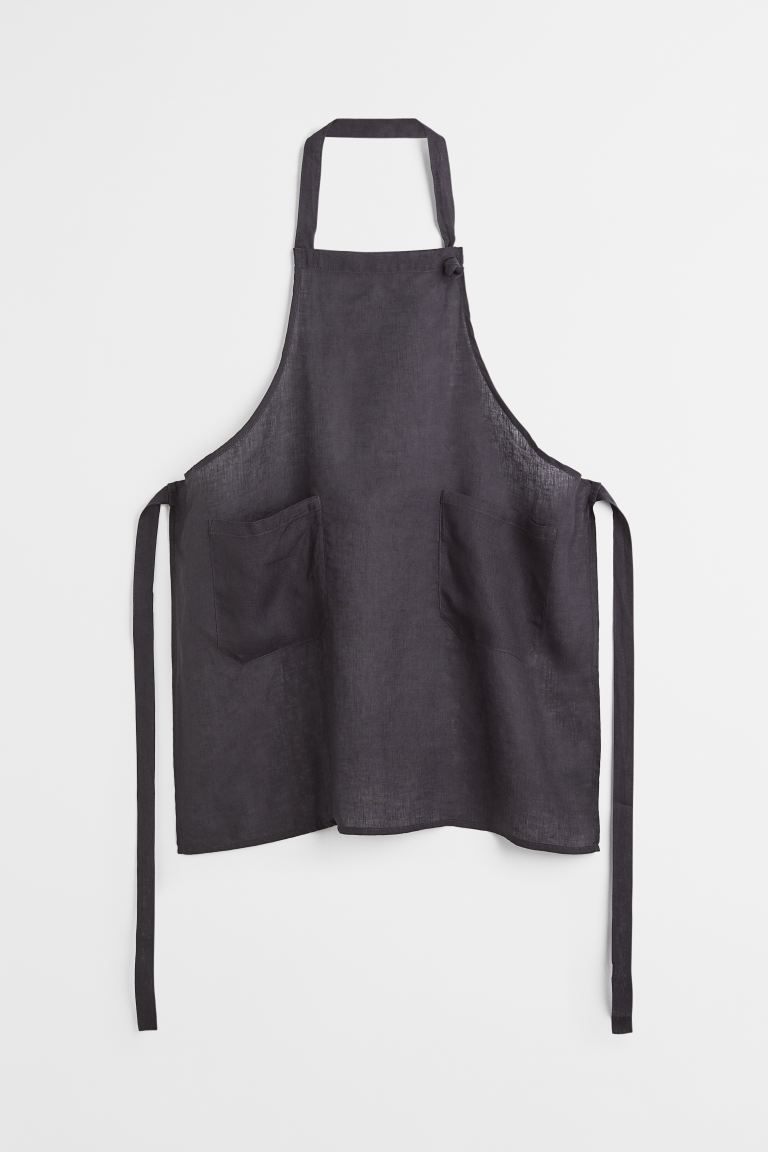 Linen apron with a strap at neck, ties at waist, and two patch front pockets. | H&M (US + CA)
