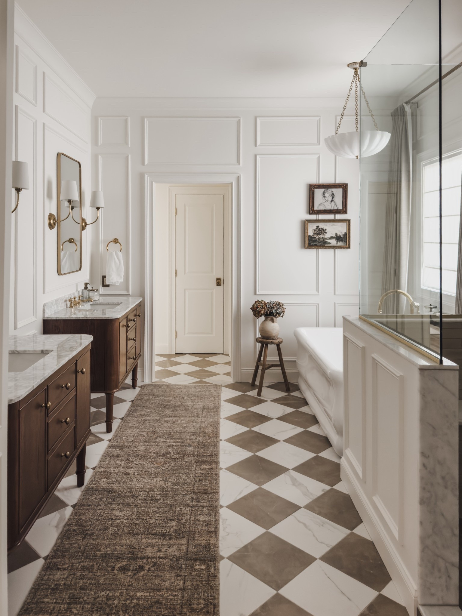 My primary bathroom reveal is finally here and I couldn’t be any more in love. From the timeless checkered flooring detail to the rich wood tones of my builder grade vanities - rounding up all of the details for my chic yet classic bathroom space.

All of my flooring is from Boardwalk Hardwood - message me on IG for all of the details. 🤍

Loved my Loloi rug in the living room so much that I ordered it as a runner for this space and couldn’t be any more obsessed.

Home finds, interior design inspo, primary bathroom reveal, vanity details, furniture favorites, neutral rug runner, bathtub, lighting detail, collected style, Home Depot, Four Hands, Visual Comforts, brass detail, wall mirror, gallery wall, wooden stool, faux florals, shop the look!#LTKStyleTip

#LTKSeasonal #LTKHome