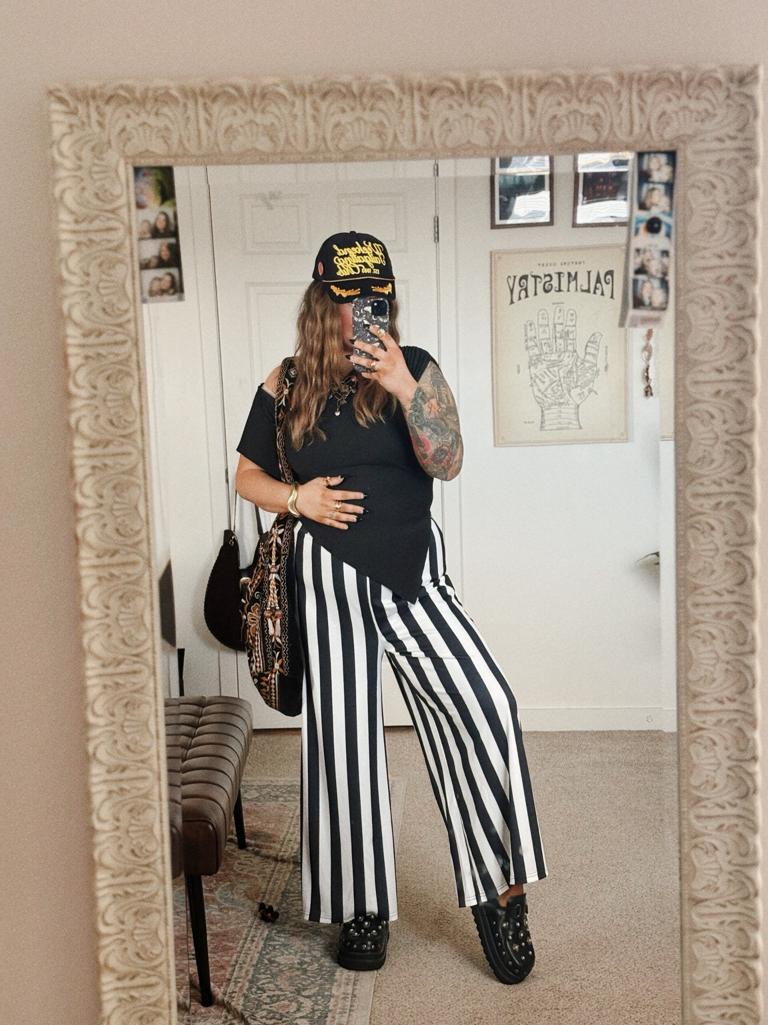 
Alt mom outfit inspo with major elder emo energy. This look mixes edgy and comfortable pieces that work perfectly for a midsize size 12 style. Black asymmetrical top paired with bold black and white striped wide leg pants creates a statement silhouette that still feels easy to wear. Styled with chunky black platform shoes, layered jewelry, and a boho crossbody bag for that alt meets effortless cool mom vibe. A perfect outfit idea if you love alternative fashion, elder emo style, and expressive midsize mom outfits that feel confident and comfortable.

#LTKPlusSize #LTKMidsize