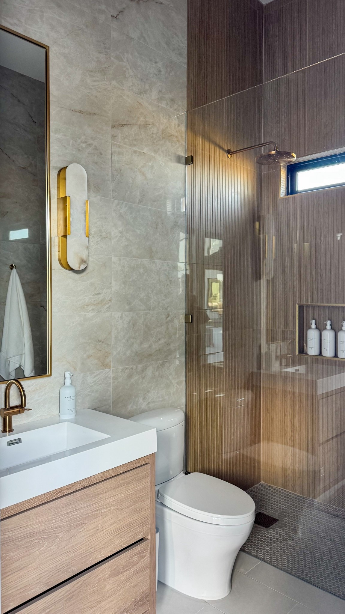 Okay, she’s finally done. We wanted this bathroom to feel calm and neutral with a touch of modern, kind of like a resort bathroom for everyday life. Every time I walk in, it just feels ahhh.

I can’t link the wall tiles, but they’re the Perla Venata Quartzite Polished Porcelain Tiles from Floor & Decor. The Moen fixtures were a little tricky to match, but after a few too many orders, I finally found pieces that complement each other perfectly. You’re welcome.