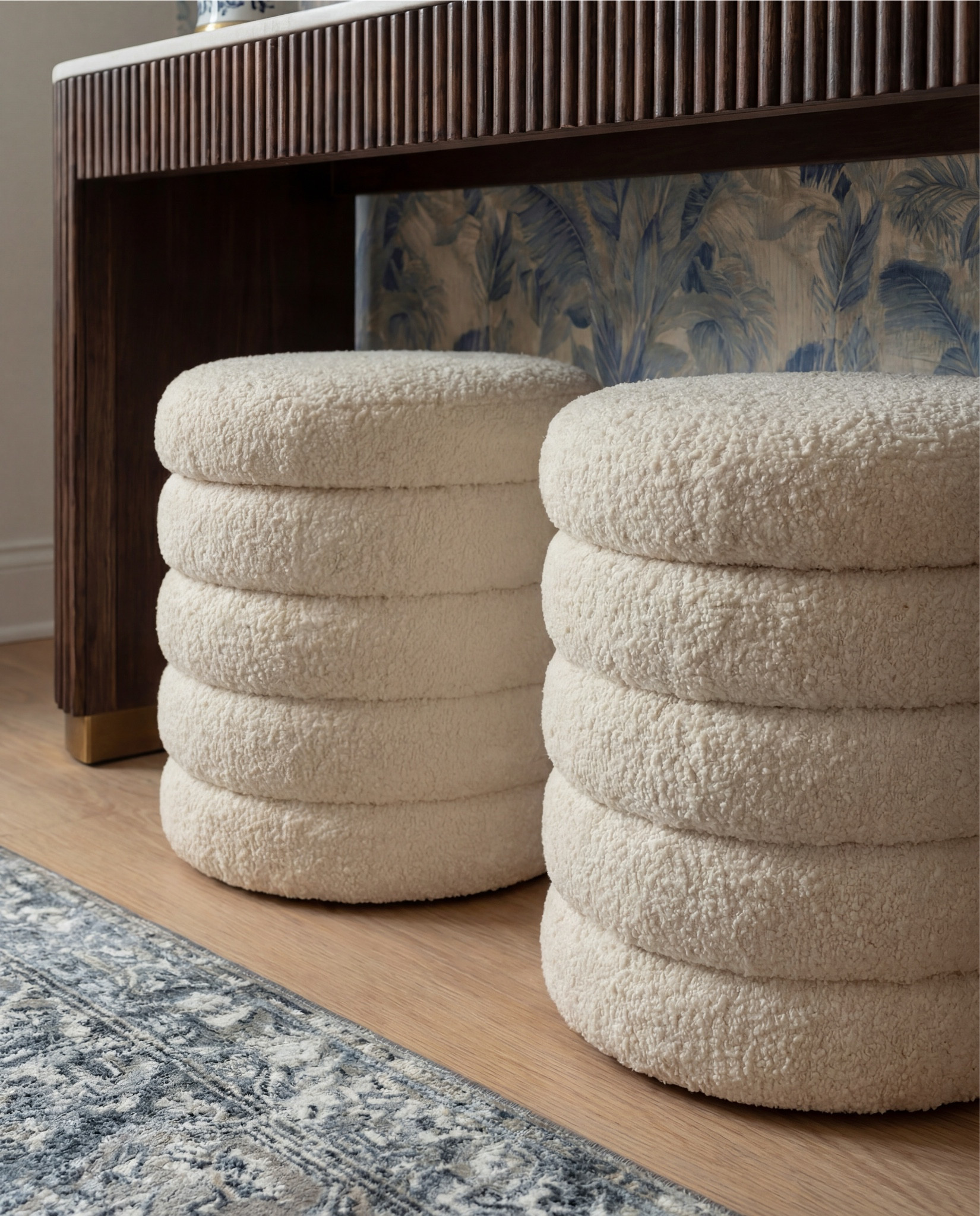 Shop the Look:
• Blue botanical wallpaper (leaf motif, muted navy + beige)
• Solid wood console table (dark walnut finish)
• Fluted wood console table legs
• White marble console tabletop
• Framed vintage floral wall art (dark wood frame)
• Brass wall sconces with white globe shades
• Blue and white ceramic table lamp
• White fabric lamp shade (tapered)
• Wooden decorative tray (rectangular)
• Stacked neutral coffee table books
• Sculptural ceramic bowl (cream stoneware)
• Distressed ceramic vase (antique white)
• Dried branches or twigs arrangement
• Bouclé ottomans (ivory, round)
• Light wood flooring
• White baseboards and trim

#LTKHome #LTKSaleAlert #LTKFindsUnder100