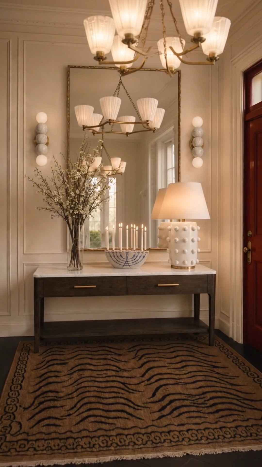 Coming home to an entry that feels warm, collected, and quietly dramatic. ✨

I love how the Danny Console gives this space such a strong architectural presence. It’s craftsman-built from oak with a hand-applied finish, and this mocha tone feels especially rich against the lighter walls. What really makes it for me are those substantial column-like legs—they bring in a classical architectural detail without making the piece feel heavy or overly traditional. The white Carrara marble top adds a beautiful natural contrast, while the brass drawer pulls give it just enough warmth and polish.

The Arren Mirror is another detail I love here. Its slim frame is crafted from cast iron with a brass finish, giving the oversized mirror a more substantial, collected feel while still keeping the profile clean and refined.

Then the chandelier glow, sculptural lamp, candlelight, flowering branches, and zebra-inspired rug bring everything together. It feels elegant and layered, yet still warm and inviting—the kind of entrance that makes coming home at the end of the day feel especially good.

Arhaus up to 50% off is going on right now.

#ModernClassic #TimelessDesign #Entryway #EntrywayDesign #EntrywayDecor #ConsoleTable #MarbleConsole #StatementMirror #Chandelier #TableLamp #Candlelight #ZebraRug #ClassicInteriors #HomeDecor #InteriorStyling #LTKHome #LTKSaleAlert #LTKdayinmylife #LTKHome #LTKSaleAlert

#LTKdayinmylife #LTKHome #LTKSaleAlert