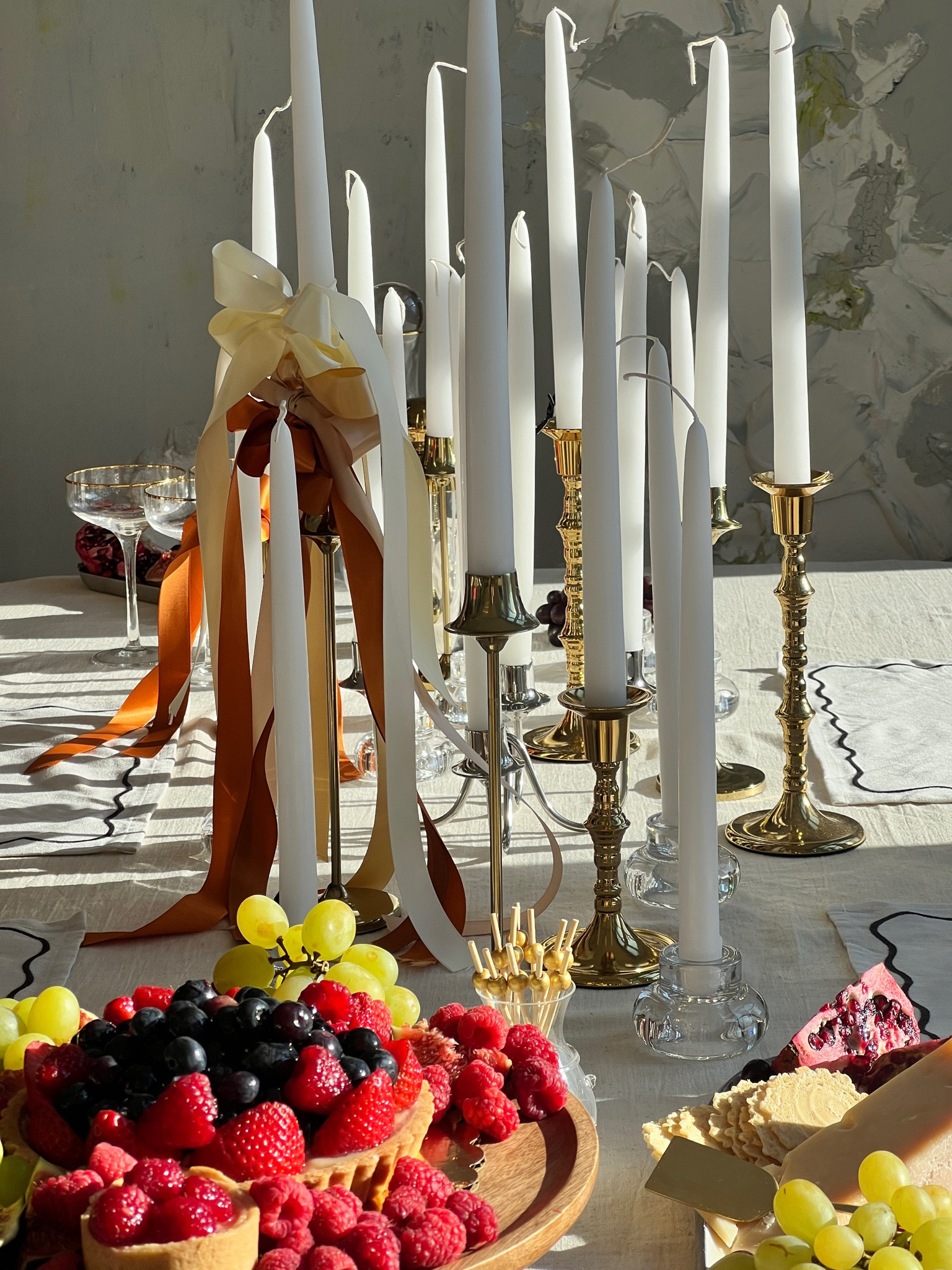 The perfect affordable table setting for the holidays or hosting girls night with gorgeous gold candlesticks, a silver candelabra, linen tablecloth, gold trimmed champagne coupes, black scalloped edge placemats and red bows galore 

#LTKHoliday #LTKhome #LTKfindsunder50