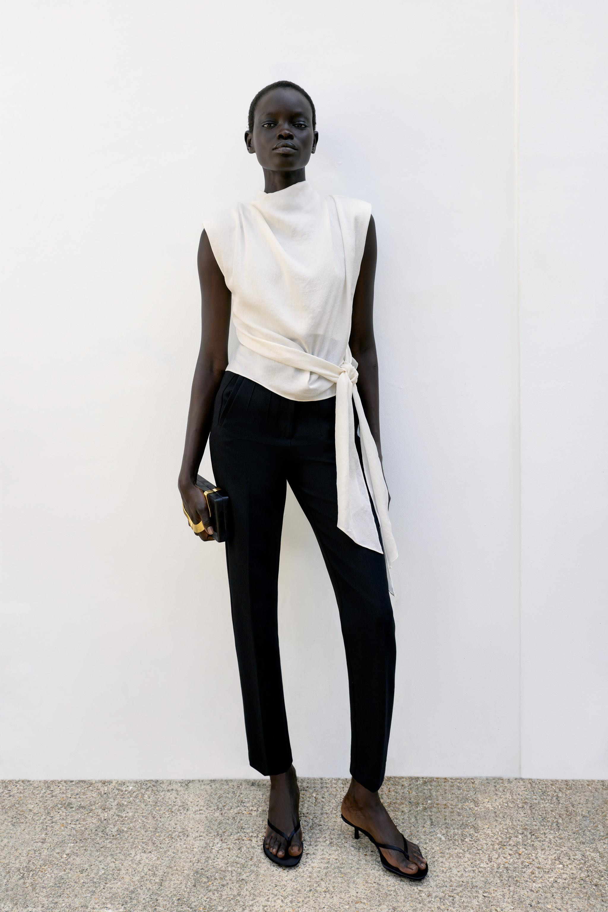 Sleeveless top with a high neck, shoulder pads and pleats. Featuring a knot detail at the hem and... | Zara DE