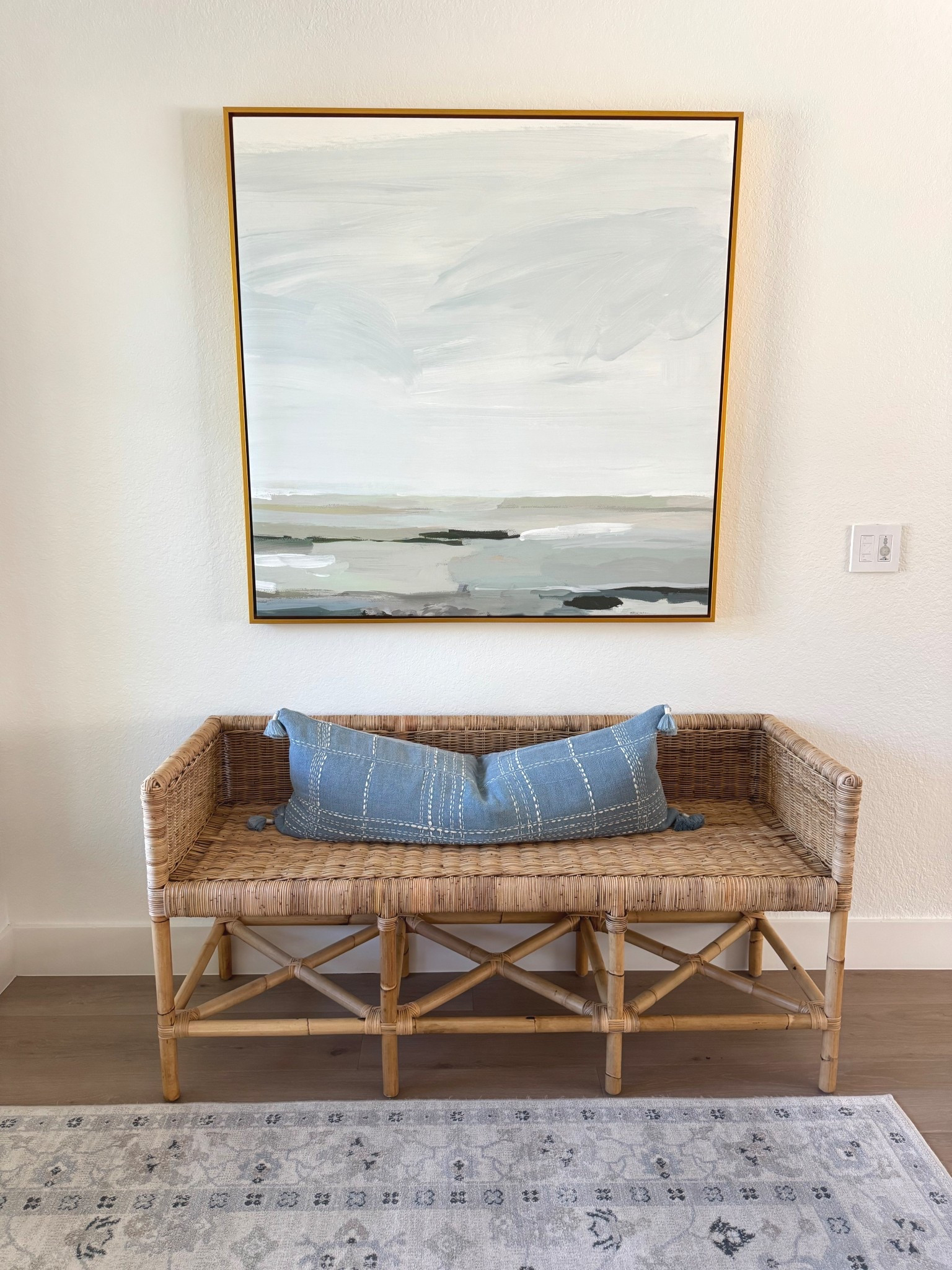 Coastal chic entry way with blue Serena and lily vibes. Welcome your guests and give them a perfect place to perch and put on shoes or lay their bag on this cute wicker bench peaceful art and soft blue rug.

#LTKStyleTip #LTKFamily #LTKHome