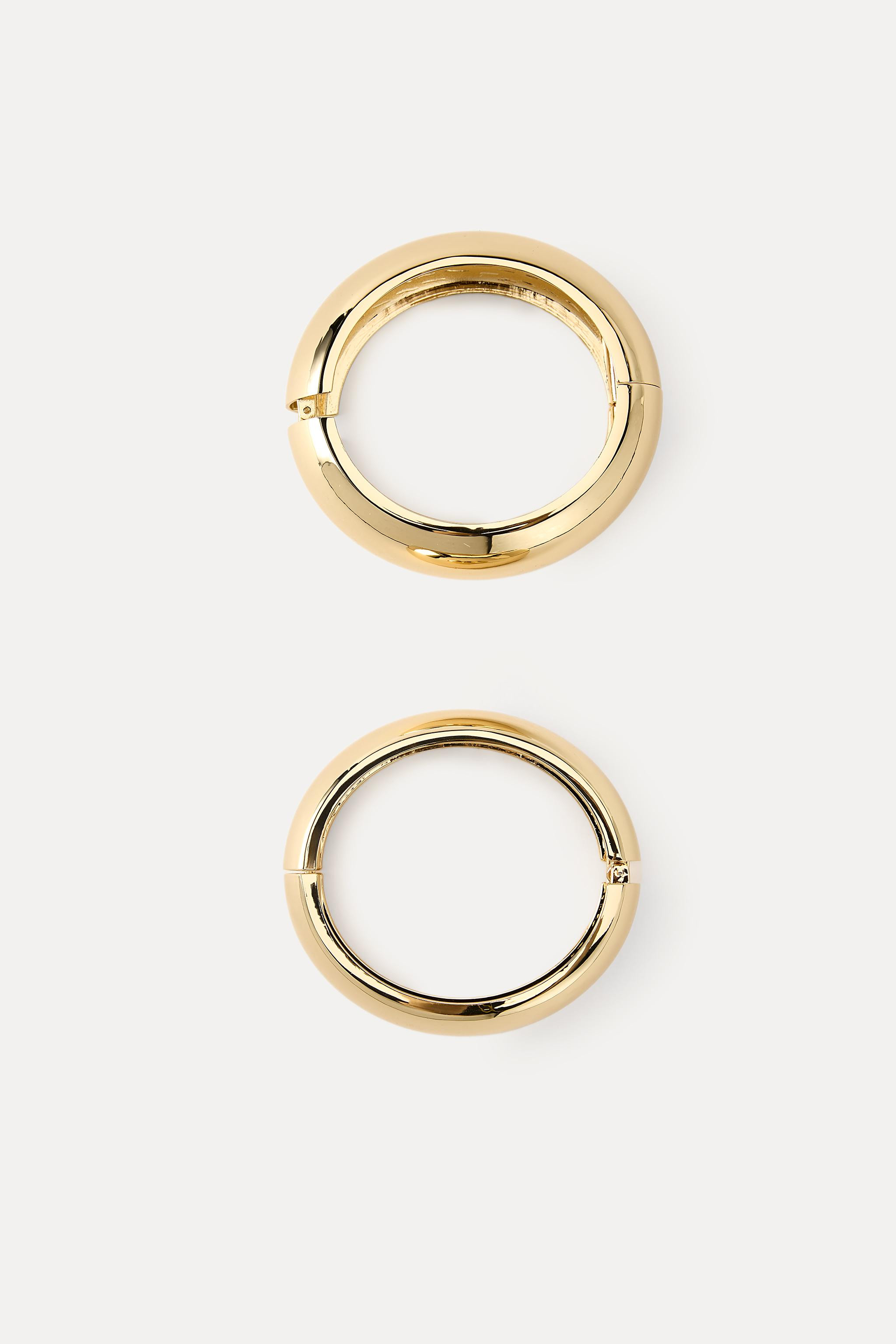 Pack of two rigid embossed metallic bracelets. Clasp fastening. | Zara US