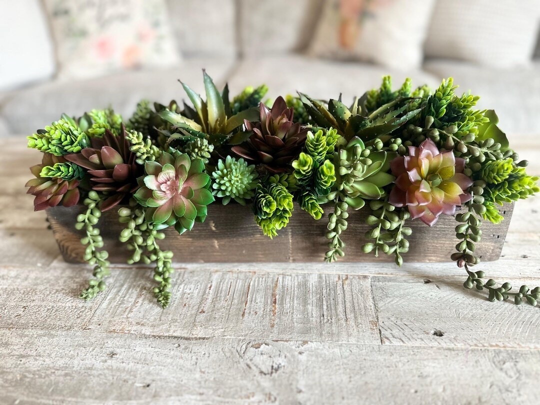 Elevate your space with this stunning rustic succulent centerpiece by CountryHomeandHeart, designed to bring natural beauty without the upkeep. Filled with incredibly lifelike faux succulents and set in a handcrafted wooden planter box, this piece blends perfectly with farmhouse, modern, or boho decor. With multiple sizes and custom wood finishes to choose from, it’s an effortless way to style your table, mantel, or event with year-round greenery. #LTKHome #FarmhouseDecor #SucculentStyle #TableCenterpiece #HomeStyling #BohoHome #NeutralDecor #EasyDecor

#LTKHome #LTKSeasonal