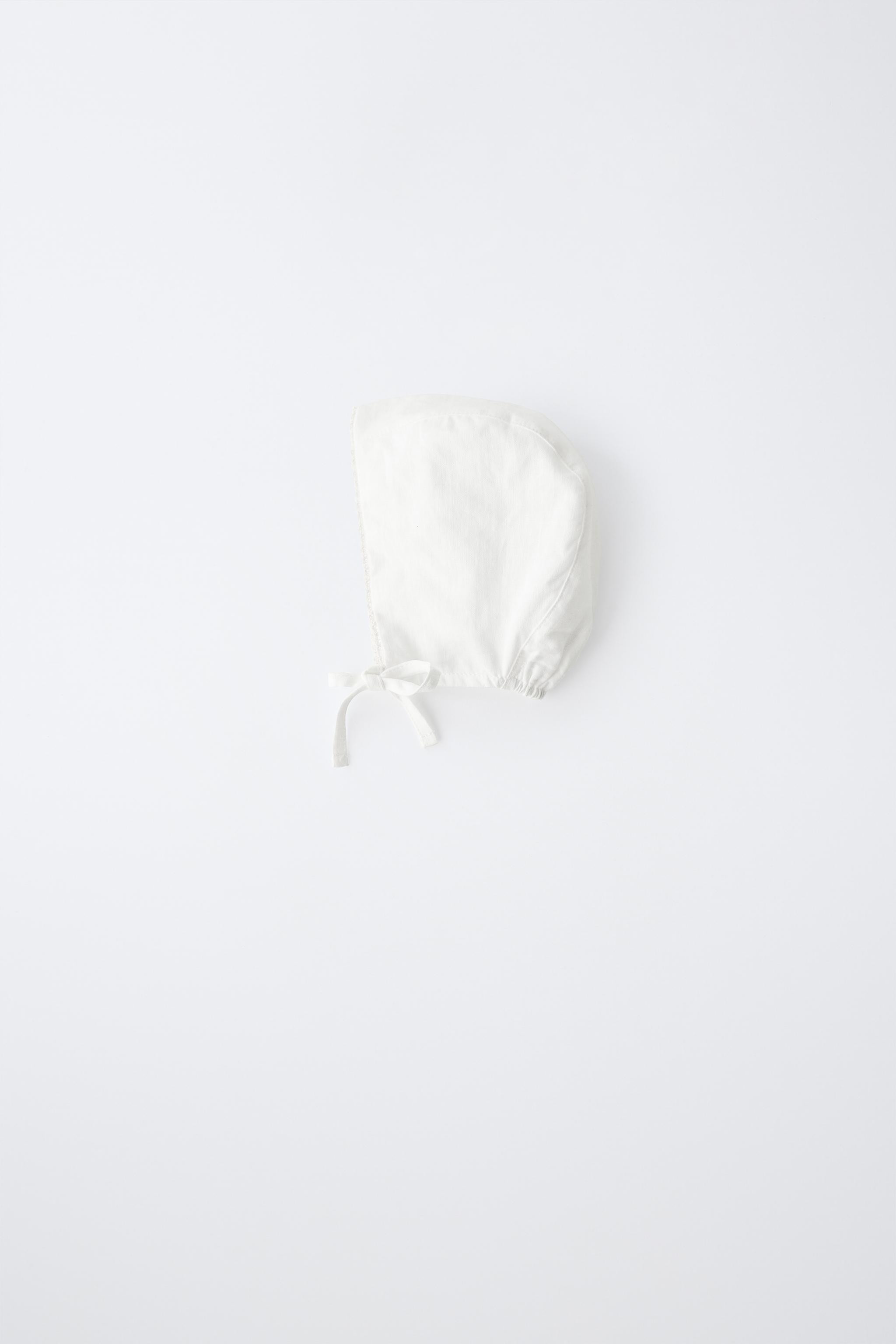 Bonnet with adjustable front closure. Lace appliqu\u00e9. Main fabric with 55% linen and 45% cott... | Zara US