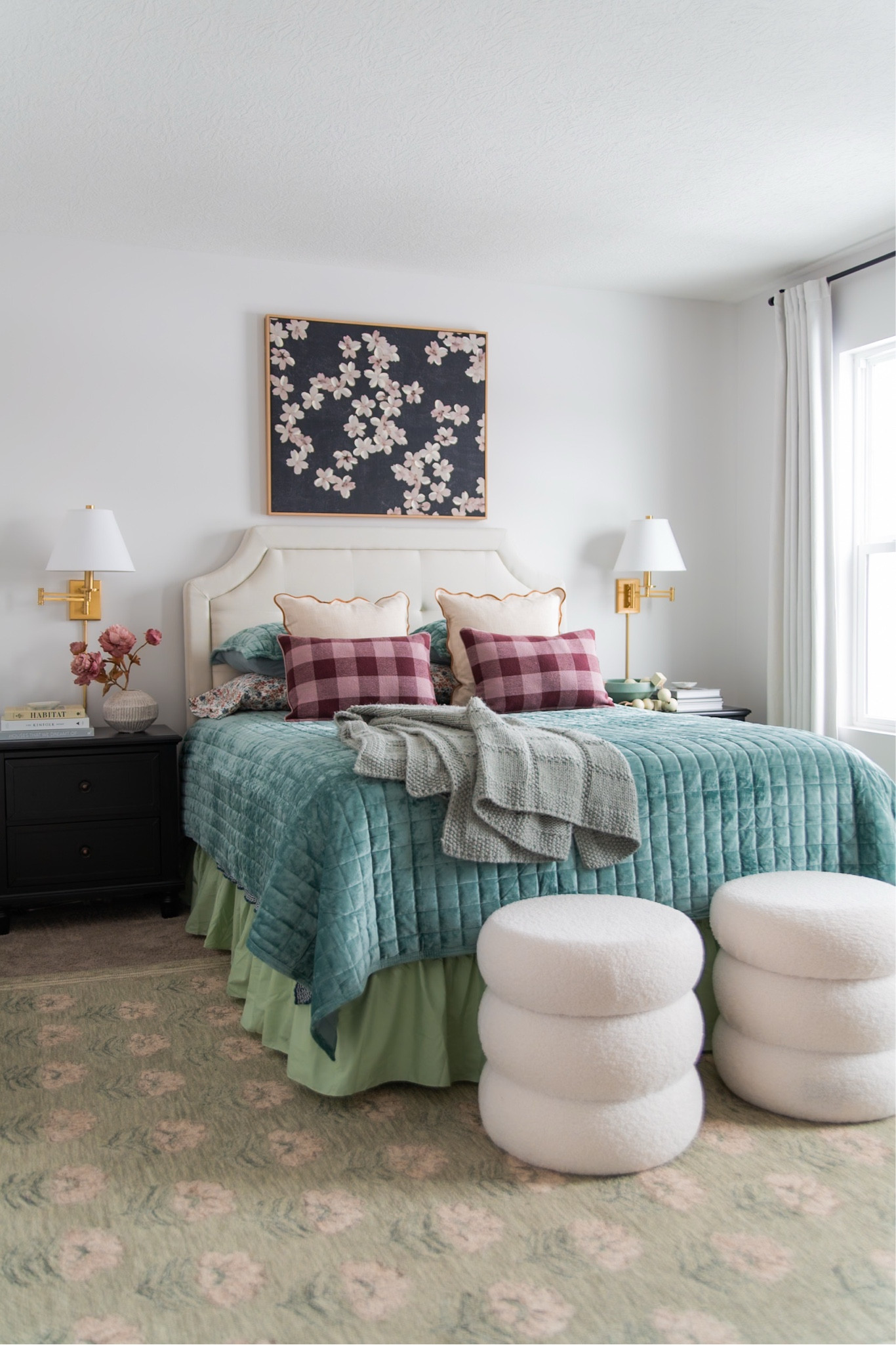 Colorful spring bedroom decor, round storage ottomans, large canvas wall art, cream upholstered headboard, ruffled bedskirt, brass wall sconces, target curtains.

#LTKMostLoved #LTKHome #LTKSeasonal