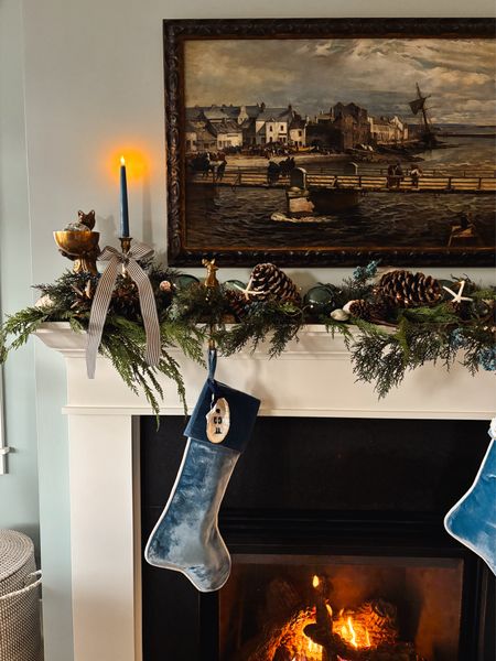 Our coastal Christmas mantel 🎄🌊 velvet stockings, oyster shell ornaments, blue battery taper candles, brass fox figurine with bowl, garland 

#LTKhome #LTKsalealert #LTKHoliday