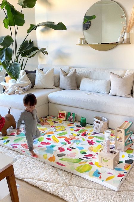 Every morning we spend 5-minutes to transform our living room into a safe play space. We pull out a folding mat, and a few toys.

Every night we throw all the toys in baskets, and put away the folding mat.

Couch is  from Interior Define