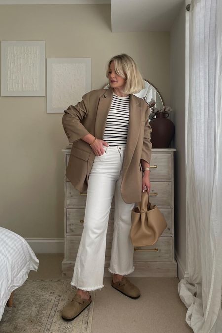Beige & white chic outfit for spring. Frankie shop khaki beige blazer, H&M striped vest top, white wide leg jeans, Birkenstock bottoms and polene paris handbag  

#LTKstyletip #LTKSeasonal #LTKeurope