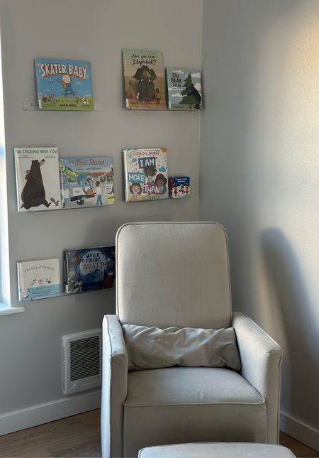The perfect reading corner. Our swivel glider rocking chair is well loved. We’ve had it almost 5 years. It comes with an ottoman. The clear shelves are perfect to display books. They help keep the books organized and I like how they display the covers for easy viewing. 

#LTKbaby #LTKhome #LTKkids