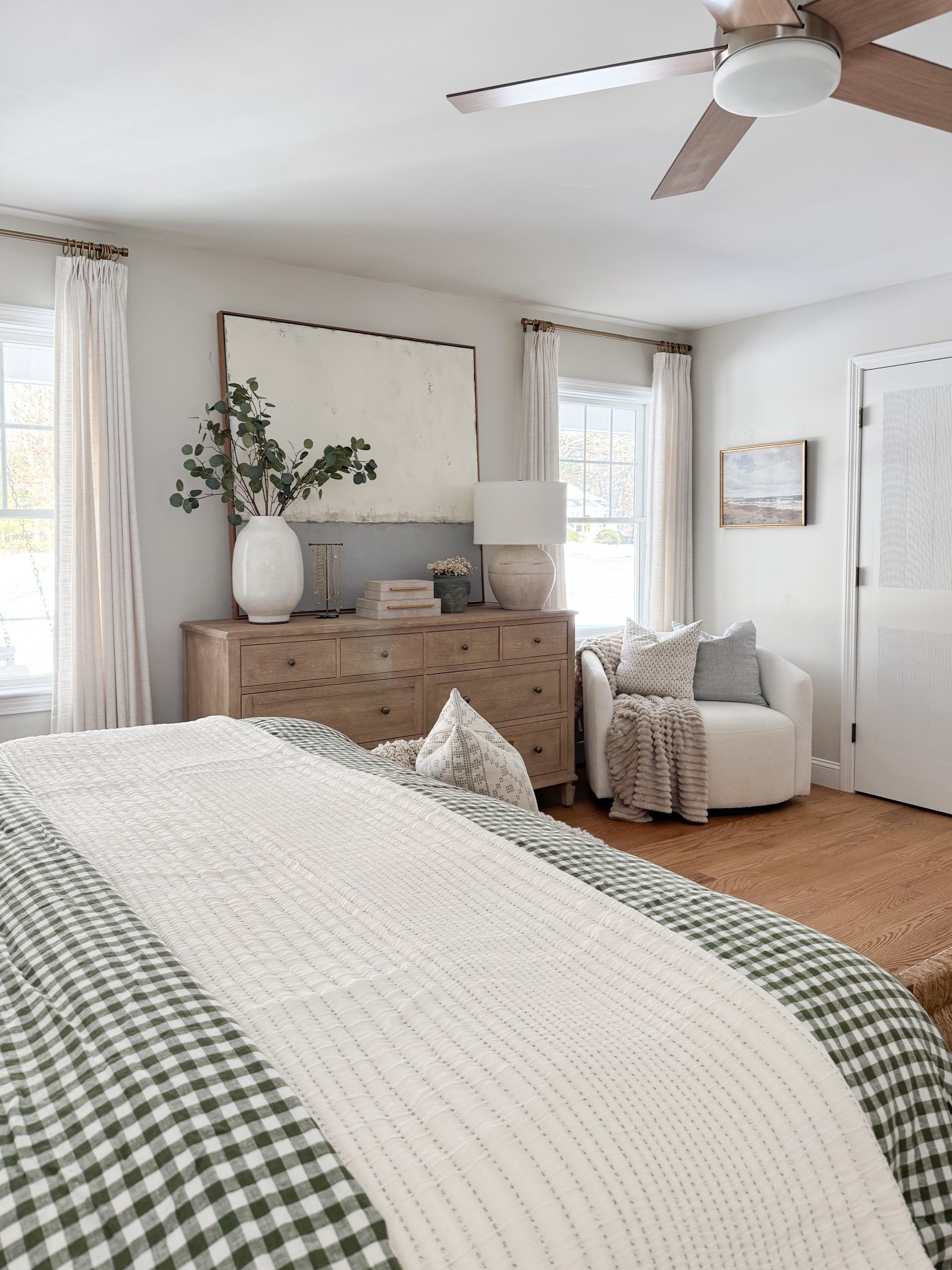 Neutral coastal bedroom with gingham bedding, layered throw blankets, textured knit coverlet, and soft patterned pillows. Light wood nightstands and white table lamps create a calm, layered spring bedroom look. 
gingham bedding, neutral bedroom decor, layered bedding, spring bedding, coastal bedroom, throw blanket, knit coverlet, patterned pillows, light wood nightstands, white table lamps, cozy bedroom, serene bedroom style, sherri calnan home

#LTKHome