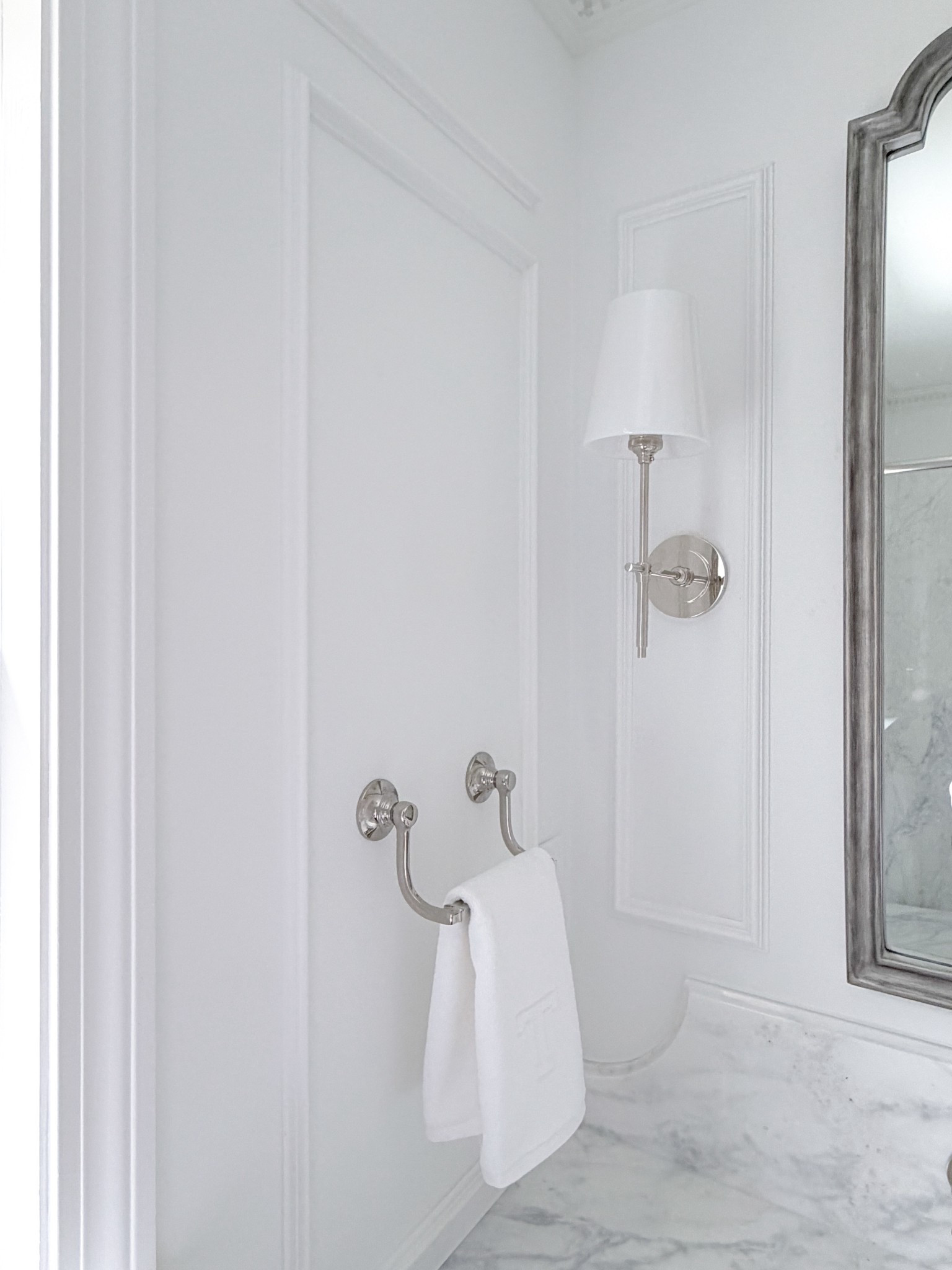 Polished nickel milk glass shaded bathroom sconce with coordinating polished nickel elegant hand towel holder with a white on white monogrammed fingertip towel 

#LTKSaleAlert #LTKHome