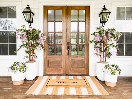 Spring Front Porch!! Loving these wisteria trees! Use BRUNOANDLIBBY for 30% off at nearly natural! Jute rug is 4x6. Front porch and front door decor large white planter trending viral home decor pottery barn dupe look a like look for less artificial faux plants trees flowers florals greenery modern farmhouse southern porch lantern, outdoor light fixtures, wall sconces lighting silk faux flowers d geraniums, hydrangeas kalanchoes pink florals jute rug scatter rug welcome mat doormat, double layered

#LTKhome #LTKstyletip #LTKSeasonal