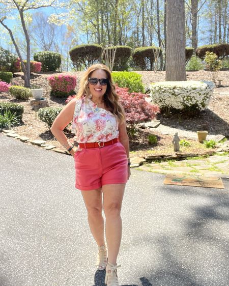 Rose faux leather shorts with a pretty asymmetrical floral one shoulder blouse. I am in love the color and length! The perfect Summer Outfit. My Azaleas are in bloom and serve as a great backdrop!