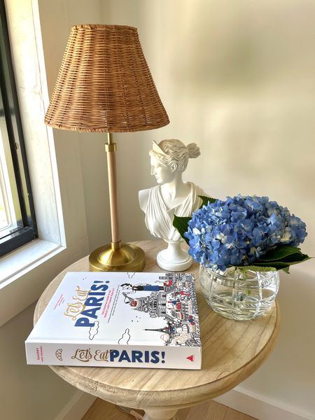#ad Modern coastal side table decorating with Wayfair featuring fresh hydrangeas, a Versailles bust sculpture, an affordable rattan table lamp, and my current read! #wayfair

#LTKHome