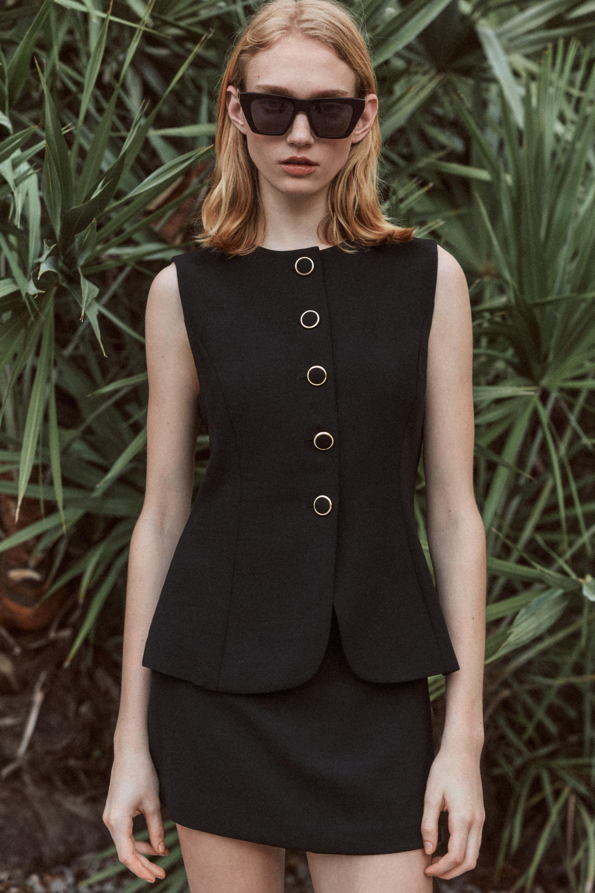 Sleeveless playsuit with a round neck. Featuring a skirt overlay on the front, button fastening o... | Zara UK