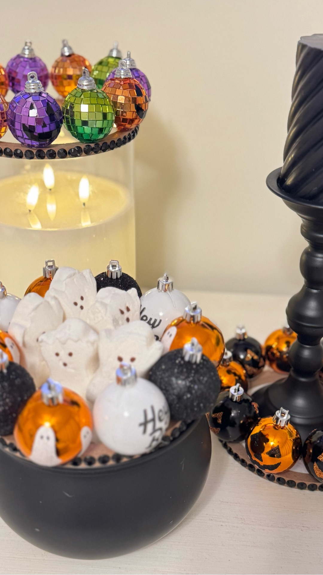 A chic and spooky Halloween centerpiece idea you can easily recreate! 🎃🕯️ I used mini disco ball ornaments in orange, green, and purple to trim my candle jars and cauldron bowls — mixing in ghost Peeps and glittery black baubles for a fun pop. Add black rhinestone jewel tape around the rims for extra sparkle and dimension. Perfect for a Halloween bar cart, entryway, or cozy tabletop display.

#halloweendecor #justjennsdesign #falldecor #diyhalloween #halloweenvibes #homedecor #halloweencenterpiece #spookyseason #halloweenaesthetic #halloweeninspo #ltkhome #ltkhalloween #ltkdecor #ltkholiday #ltkseasonal #interiordesign #festivedecor #boo #halloweencraft #holidaystyle