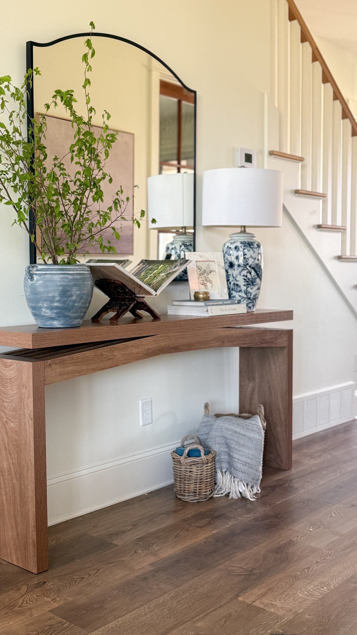 A look at our entryway styled for spring 🌿

I’ve been loving this new console table and mirror from @Wayfair . The narrow depth made it possible to add a table along this wall without cutting into the walkway, which completely changed how this space functions.

I kept the styling simple with a blue and white ceramic lamp on one side and a vase of stems on the other. I used an open book with spring landscape photography as art, then layered in a marble frame, a few stacked books, and a spring candle.

For now, I have two baskets underneath, but I plan to swap those for ottomans soon.

I’ve linked what I could below to recreate this look. 

#ad #wayfair #wayfairpartner


#LTKSeasonal #LTKHome