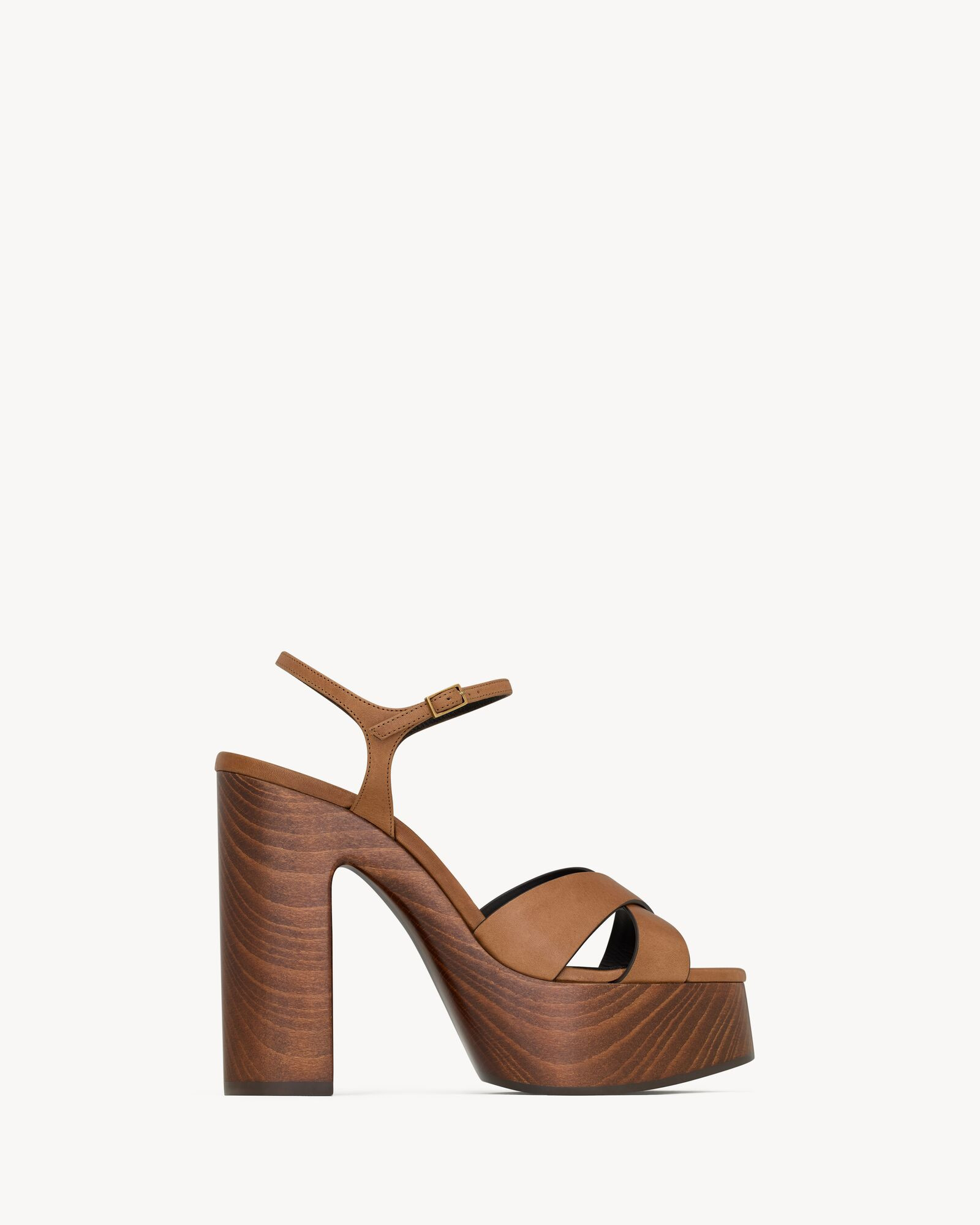 Platform sandals with a crisscrossed front, featuring an adjustable ankle strap and wooden block ... | Saint Laurent Inc. (Global)