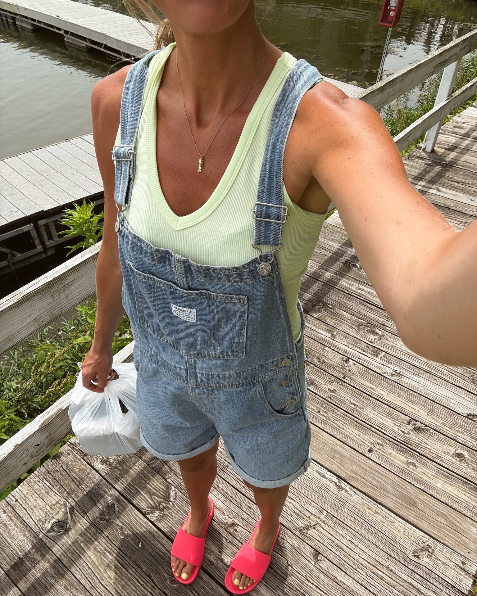 Outfit I wore over my swimsuit to the lake this weekend. I am wearing my true size in the @levi  overalls, my true size in the FP movement tank and my true size in the @abercrombie  swimsuit. I also really love these new slides from @lululemon  the color is so fun!￼