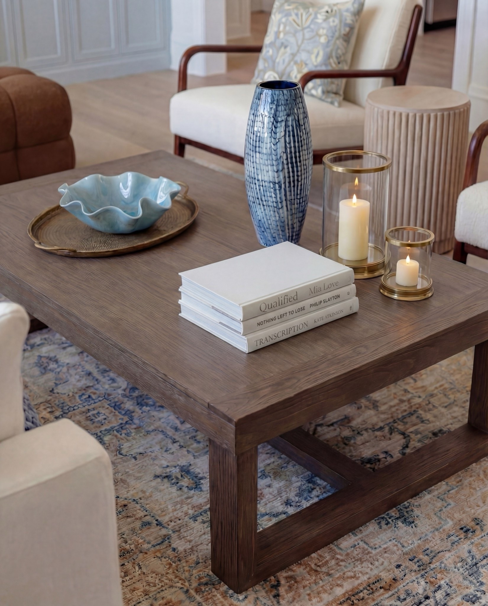 Shop this look:
• Exposed wood ceiling beams
• Blue floral wallpaper (ceiling + vaults)
• Marble fireplace surround
• Gas fireplace insert
• Framed neutral landscape artwork
• Built-in bookcases with lower cabinetry (soft blue-gray)
• Styled books + neutral ceramic decor
• Cream upholstered sofa
• Blue chunky knit throw blanket
• Blue and neutral accent pillows (patterned + solid)
• Upholstered accent chairs with wood frames
• Brown leather ottomans
• Rectangular wood coffee table
• Blue ceramic decorative vase
• Blue decorative bowl
• Stacked coffee-table books
• Light blue patterned area rug
• Small round wood side table
• Table lamp with white shade
• Floor-to-ceiling windows with sheer white curtains

#LTKSpringSale #LTKHome #LTKSaleAlert