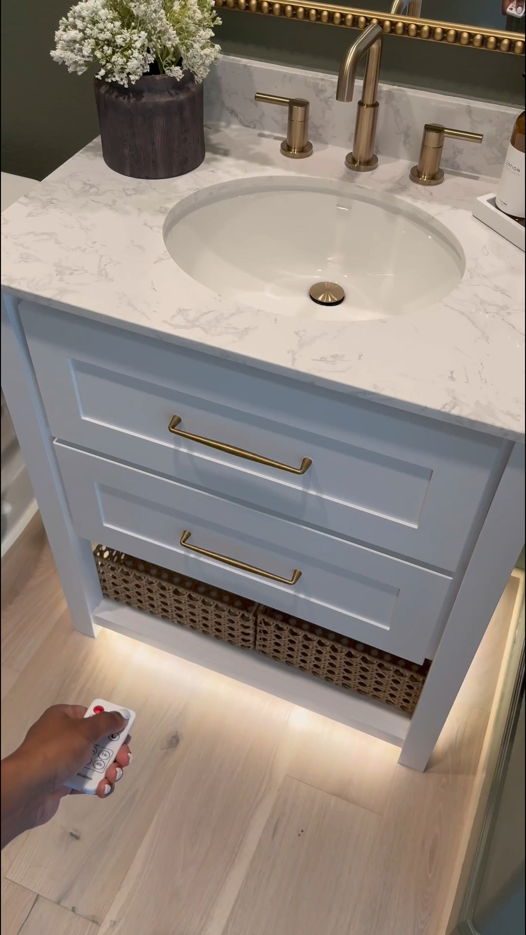 If you’re considering painting your powder room green, I’m telling you, THIS might be the perfect color for you … go for it! 

I used flat finish for the walls and painted the baseboards in satin finish… 

I’ll be honest, I was apprehensive at first … I even paintings the ceiling 😬 believe it our not, it made the room feel larger! 

I chose brass finishes bc I really wanted the space to have a vintage feel… well, modern vintage…??? If that’s a thing 😆.. 

The mirror is 30x40 inches… 

I added a new light fixture and it now faces upwards … which made that wall feel taller 

I wasn’t in love with this builder grade vanity tbh😆, matter-fact, I wanted to change it… it wasn’t functional …but now i wanna keep it lol 😂… I added brass hardware, these cute baskets from Walmart, led light strips on the bottom and now it’s a whole new unit….. you can even add battery powered/rechargeable/plug in led light strips .. whatever fits your lifestyle 

Ok let’s talk about this stunning planter!!! …. You know I love me an olive tree 😆… and I wanted something tell and slim… this planter was the perfect for plus it added to the moodiness 🥰

I am in love with this space… I wanted to create a vintage-cottagy feel in this powder room, while the rest of the home feels modern. #LTKVideo

#LTKHome #LTKStyleTip