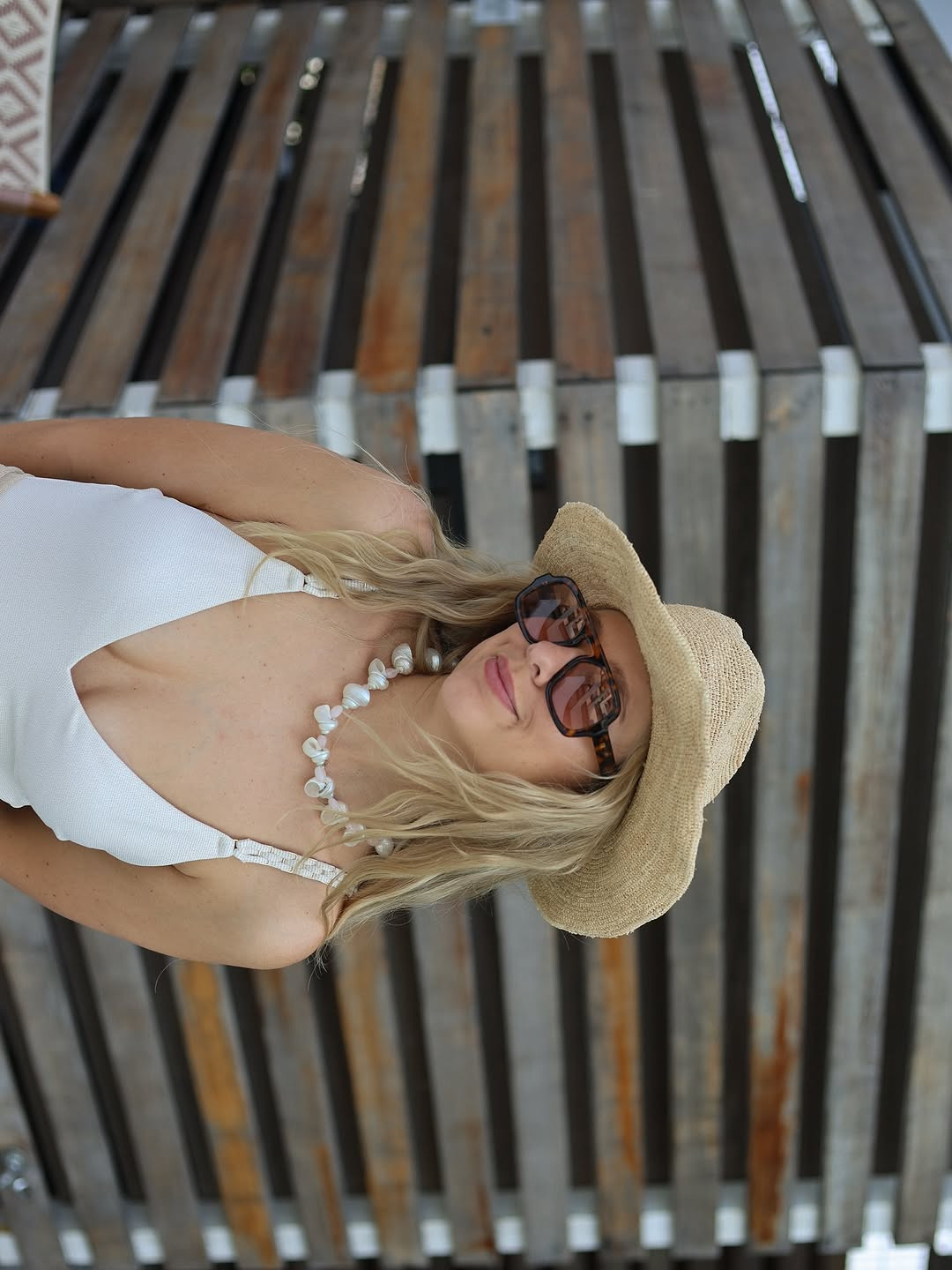 Beach day ready. This effortless look features a white V-neck swimsuit paired with a straw sun hat, oversized tortoiseshell sunglasses, and a shell-and-pearl necklace. #SummerAccessories #BeachStyle #LTKbeach 

 #LTKdayinmylife #LTKootd #LTKSeasonal