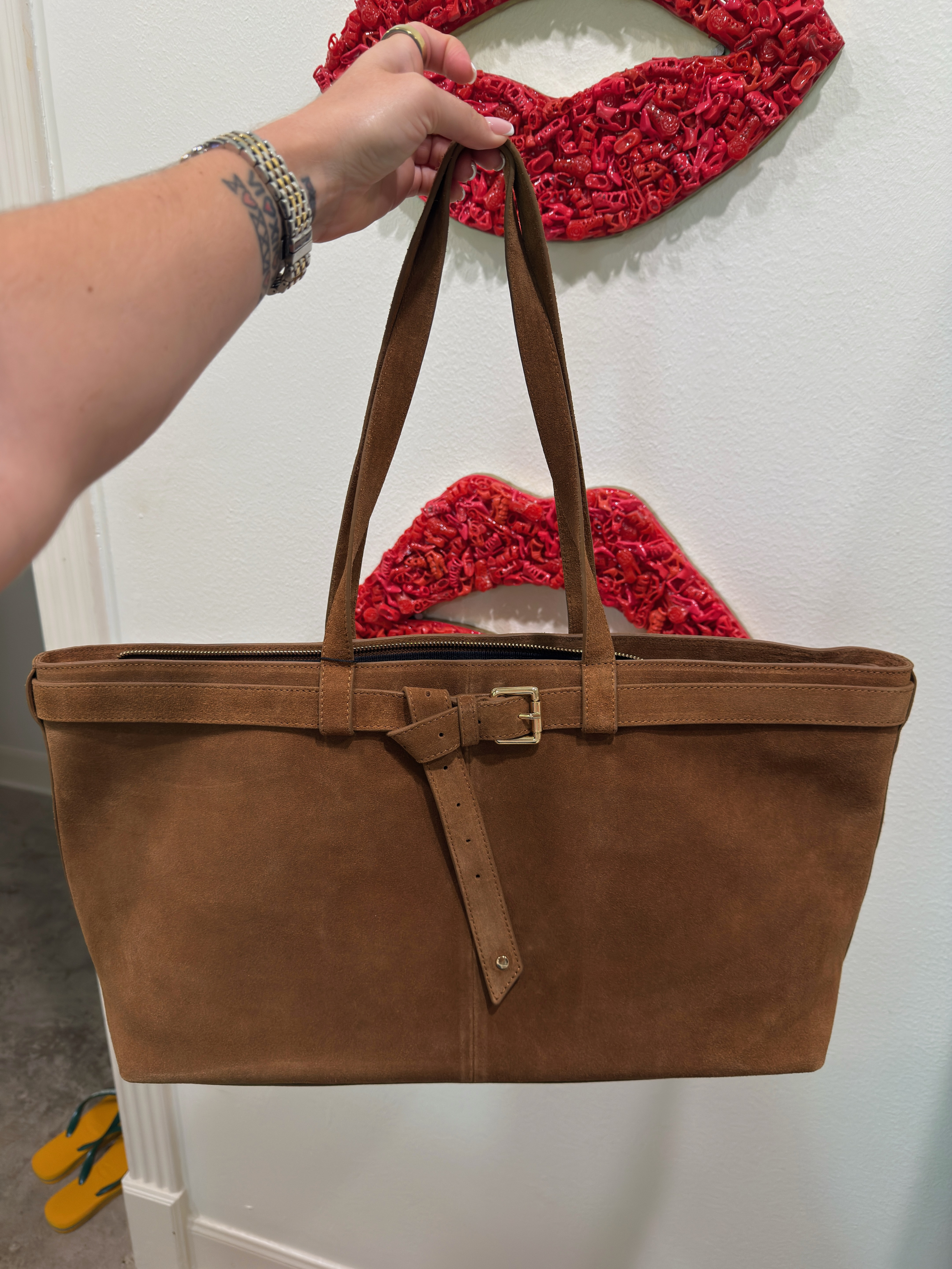 The tote that makes you look like you have your life together — even when you don't.Apatchy London's cognac suede tote is the structured everyday bag I've been reaching for on repeat. The buckle belt detail at the front is what elevates it from a basic tote to something that actually has a point of view — gold hardware, clean lines, zip closure across the top so your things stay where you put them. The cognac suede reads warm and rich without being precious about it. At $326 it's the bag that works harder than most things at twice the price. Wide enough to carry everything you actually need, structured enough to hold its shape on your arm or on a chair without collapsing. Wear it with wide-leg trousers and a blazer for a meeting, with jeans and a simple top for a weekend lunch, or with literally anything beige, cream, or white and watch it tie the whole outfit together.The honest note: suede needs protection spray before you take it anywhere — treat it before first wear and it'll hold up beautifully. 

 