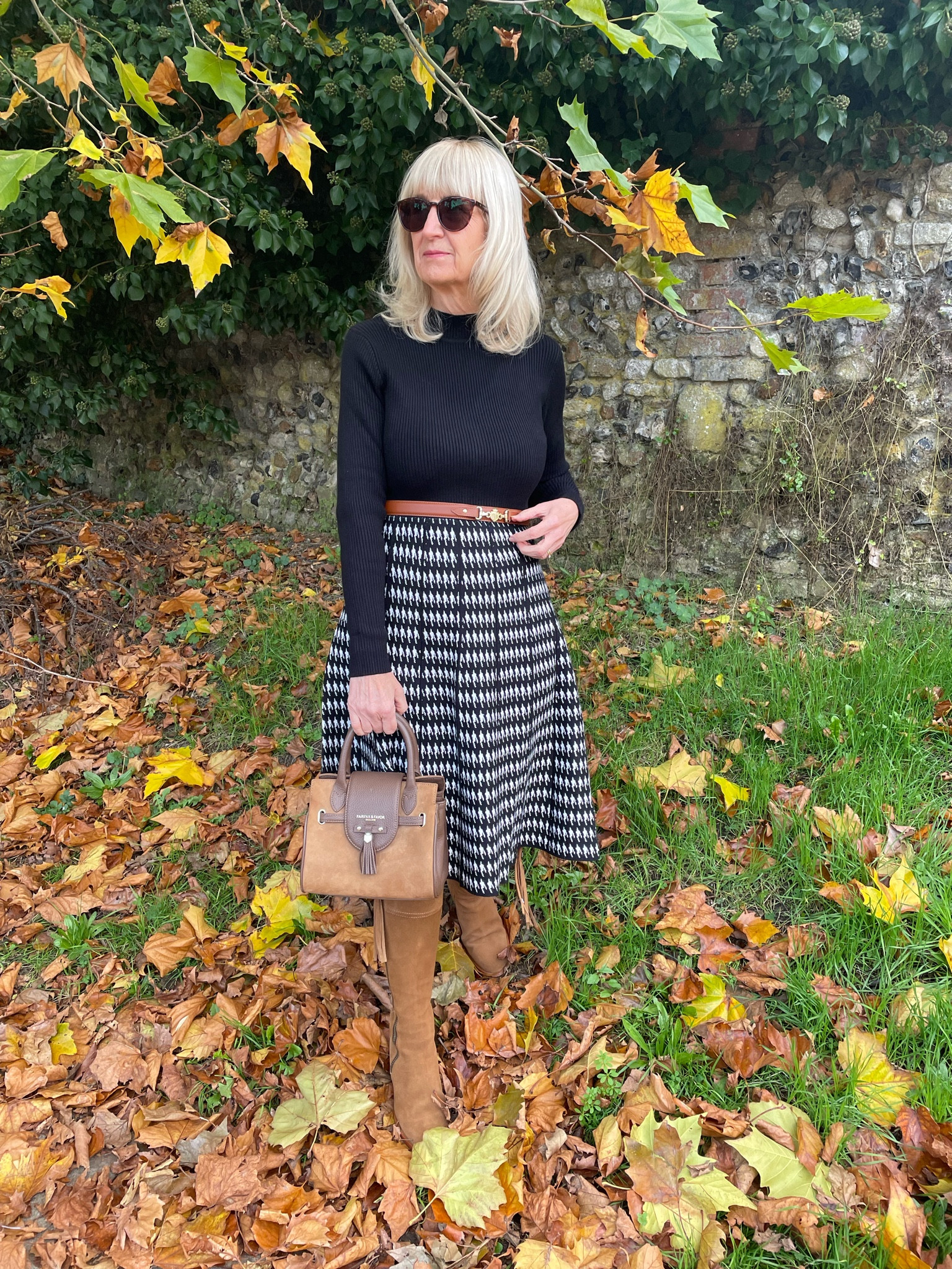 Autumn Outfit 
Fit and flare jumper dress with a black long sleeved top and pleated effect houndstooth skirt. Tan boots, bag and belt. The perfect workwear dress 

#LTKworkwear #LTKwinter #LTKautumn