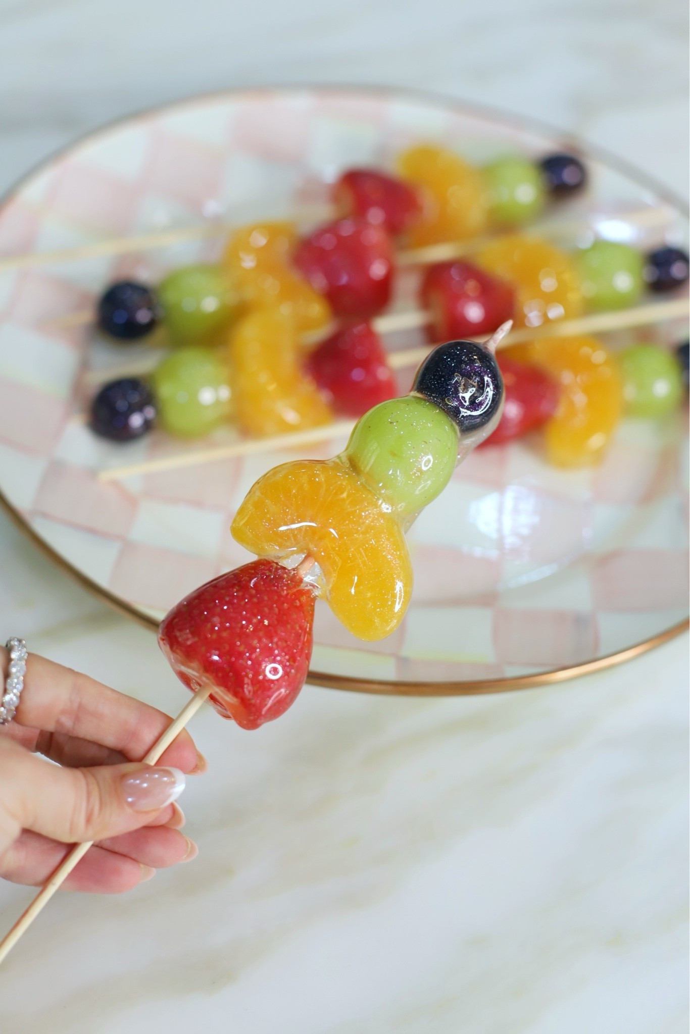 Just a little afternoon pick me up 😉

These candied fruit screwers really are the perfect way to elevate a party / and or your everyday fruit plate to make it a treat ✨

INGREDIENTS:
- Fruit of your choice (I prefer fruit with skin to keep the juices in) 
- 2 cups sugar
- ½ cup water
- ½ cup karo syrup
- Vanilla + Edible glitter (optional)

Wash a dry fruit. Be sure to blot dry as much juice as possible otherwise candy will not stick. Place on skewers and freeze while making candy mixture. Boil sugar, water, and karo syrup for about 10 minutes until mixture is 300 degrees. You will want a candy thermometer to check temperature. Remove from heat immediately. Add food coloring, edible glitter, or flavoring (optional - love vanilla and or coconut). Dip cold fruit quickly (within 5 minutes) and place on parchment paper to harden. Enjoy immediately or same day. Store in freezer to ensure juices remain inside candied shell. Since some fruit isis juicier than others, the candied shell can leak juices if not stored in freezer. #easyrecipes #fruitplate #snackrecipes #partyrecipes #recipeidea